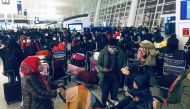 Bangladeshi citizens, mostly students, wearing facemasks wait at Wuhan airport on January 31, 2020, as the Bangladeshi government prepares to evacuate them following a SARS-like virus outbreak in the city of Wuhan. (AFP)
