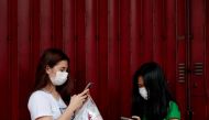Women wearing face masks use their phones in Manila, Philippines, January 31, 2020. REUTERS/Eloisa Lopez