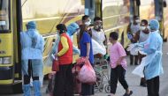  Evacuated Malaysian nationals from Wuhan, China are directed onto a bus by health officials in protective suits after arriving at Kuala Lumpur International Airport in Sepang, Malaysia, February 4, 2020. MalaysiaÕs Ministry of Health/Muzzafar Kasim/Hando