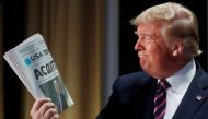 Donald Trump holds up a copy of USA Today front page showing news of his acquittal in his Senate impeachment trial as he arrives to address the National Prayer Breakfast in Washington, February 6, 2020. Reuters/Leah Millis