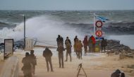 People stand on the beach as strong waves break against a jetty on the Belgian coast in Ostend on February 10, 2020, after storm Ciara swept over the country.  / AFP / BELGA / KURT DESPLENTER