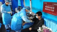 This photo taken on February 16, 2020 shows a man (R) who has recovered from the COVID-19 coronavirus infection donating plasma in Lianyungang in China's eastern Jiangsu province, aimed at curing infected patients in severe and critical conditions. China 
