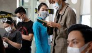 A ground staff member of Vietnam Airlines and passengers wearing a protective mask, following an outbreak of the novel coronavirus, wait for boarding at the Danang airport in Danang city, Vietnam February 23, 2020. REUTERS/Kham