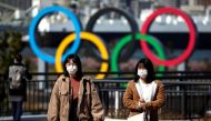 People wearing protective face masks, following an outbreak of the coronavirus, are seen in front of the Giant Olympic rings at the waterfront area at Odaiba Marine Park in Tokyo, Japan, February 27, 2020. REUTERS/Athit Perawongmetha 
