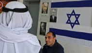 An Arab-Israeli man arrives at a poling station, decorated with portraits of Israeli politicians, to cast his ballot for the parliamentary election in the Bedouin town of Rahat near the southern Israeli city of Beersheba on March 2, 2020.  AFP / Hazem Bad
