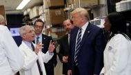 US President Donald Trump is flanked by Health and Human Services (HHS) Secretary Alex Azar and National Institutes of Health Doctor Kizzmekia Corbett, research fellow at the NIH Vaccine Research Center, as he listens to Director of National Institute of 