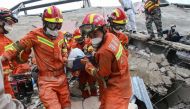 A man (C) is rescued from the rubble of a collapsed hotel in Quanzhou, in China's eastern Fujian province on March 8, 2020. At least four people were killed following the collapse of a hotel used as a coronavirus quarantine facility in eastern China, the 