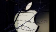 FILE PHOTO: An Apple company logo is seen behind tree branches outside an Apple store in Beijing, China December 14, 2018. Reuters/Jason Lee/File Photo