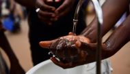 A passenger washes his hands at a public hand washing station before boarding a bus as a cautionary measure against the coronavirus at Nyabugogo Bus Park in Kigali, Rwanda. March 11, 2020. Reuters/Maggie Andresen