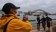 SYDNEY, AUSTRALIA - MARCH 14: People wear face masks as a preventative measure against Coronavirus COVID-19 in front of the Sydney Harbour Bridge in Sydney, Australia on March 14, 2020.  ( Steven Saphore - Anadolu Agency )
