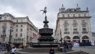 Only a few people are pictured in Piccadilly Circus on Sunday afternoon in central London on March 15, 2020. AFP / Tolga Akmen 
