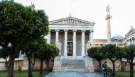 ATHENS - Greece, MARCH 17: A cleaner sweeps with a protective mask as a preventive measure against coronavirus (COVID-19) outbreak in front of the central building of University of Athens in Greece on March 17, 2020. ( Andreas Papakonstantinou - Anadolu A