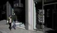 People wear protective face masks as they walk outside closed stores, as a precaution against the spread of the coronavirus disease COVID-19), on the main commercial Ermou Street in Athens, Greece, March 18, 2020. REUTERS/Costas Baltas