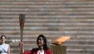 ATHENS, GREECE - MARCH 19: Former Japanese swimmer Imoto Naoko holds the Olympic torch during the olympic flame handover ceremony for the 2020 Tokyo Summer Olympics, on March 19, 2020 in Athens. T ( ARIS MESSINIS / AFP / Pool - Anadolu Agency )