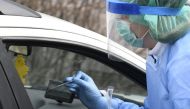 A medical member in protective clothing takes samples at a testing drive-in station for the health and hospital professionals where people can get tested for the novel coronavirus disease (COVID-19) directly from their cars, in Espoo, Finland March 18, 20