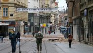People walk past debris in a street after an earthquake, in Zagreb, Croatia March 22, 2020. REUTERS/Antonio Bronic
