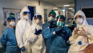 A group of nurses wearing protective mask and gear pose for a group photo prior to their night shift on March 13, 2020 at the Cremona hospital, southeast of Milan, Lombardy. AFP PHOTO / PAOLO MIRANDA