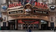 FILE PHOTO: A man cycles past a shuttered movie theater in Times Square following the outbreak of coronavirus disease (COVID-19), in the Manhattan borough of New York City, New York, U.S., March 17, 2020. REUTERS/Carlo Allegri