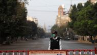 A traffic police officer stands with a barrier on a deserted road of a business district during a partial lockdown after Pakistan shut all markets, public places and discouraged large gatherings amid an outbreak of coronavirus disease (COVID-19), in Karac