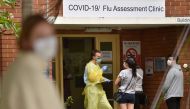 A health worker talks to visitors at a Covid-19 testing centre in Sydney on March 23, 2020. / AFP / PETER PARKS