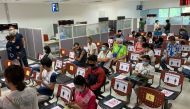 People wear face masks while waiting as chairs are marked for applicants to observe social distance at the Immigration Office in Bangkok on March 24, 2020, as Thailand moves to close its borders after a spike in the number of COVID-19 coronavirus cases in