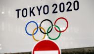 FILE PHOTO: A banner for the upcoming Tokyo 2020 Olympics is seen behind a traffic sign, following an outbreak of the coronavirus disease (COVID-19), in Tokyo, Japan, March 23, 2020. REUTERS/Issei Kato