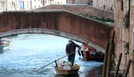 A man delivers fruits and vegetables by rowboat to his customers' houses during the current emergency of the coronavirus disease (COVID-19) in Venice, Italy, March 25, 2020. REUTERS/Manuel Silvestri