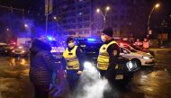 Police forces talk to a pedestrian as they watch over the freshly issued curfew in the streets of Bucharest on March 23, 2020 amid the spread of the COVID-19 (novel coronavirus).  AFP / Daniel MIHAILESCU
