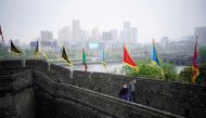 People wearing face masks walk on an ancient city wall in Jingzhou, after the tourist attraction reopened as the lockdown was eased in Hubei province, the epicentre of China's coronavirus disease (COVID-19) outbreak, March 26, 2020. Picture taken March 26