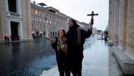 Two persons pray close to the Vatican as Pope Francis delivers an extraordinary 