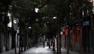 A man walks his dog in an empty street in Madrid on March 27, 2020 amid a national lockdown to fight the spread of the COVID-19 coronavirus. AFP / Gabriel Bouys