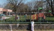 Life in lockdown: Two-year-old Bianca Toniolo looks through the gates of a closed playground close to her home in San Fiorano, one of the original 'red zone' towns in northern Italy that has now been extended to whole country, in this picture taken by her