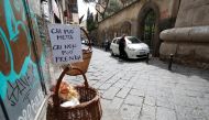 A basket hung up so people can donate or take for free food is seen, as Italy struggles to contain the  COVID-19 in Naples, Italy March 30, 2020. The sign reads: 