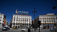 A man with a shopping trolley walks past police cars at Puerta del Sol in Madrid on April 3, 2020 during a national lockdown to prevent the spread of the COVID-19 coronavirus. More than 900 people died in Spain over the past 24 hours for the second day ru