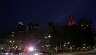 New York Police Department vehicles drive along 42nd Street as the Empire State Building is lit in red to honor emergency workers during the outbreak of coronavirus disease (COVID-19) in Manhattan, New York City, U.S. April 2, 2020. REUTERS/Andrew Kelly