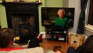 A picture shows a family in Birkenhead, northwest England on April 5, 2020 watching Britain's Queen Elizabeth II deliver a special address to the UK and Commonwealth recorded at Windsor Castle in relation to the coronavirus outbreak. AFP / PAUL ELLIS