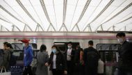 People wearing face masks get off a subway train at a subway station during morning rush hour in Beijing, as the spread of the novel coronavirus disease (COVID-19) continues in the country, in China April 7, 2020. REUTERS/Tingshu Wang