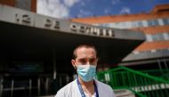 Christian Vigil, 26, an intensive care doctor, poses at the main entrance of the 12 de Octubre hospital during the coronavirus disease (COVID-19) outbreak, in Madrid, Spain, April 8, 2020. REUTERS/Juan Medina