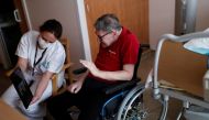 Health worker Emilie Neumann helps a 79 year-old resident to attend an online video call with his relatives at Les Jardins d'Emeraude long-term care unit at Bischwiller departemental hospital, near Strasbourg, during a lockdown imposed to slow the spread 