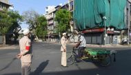 Volunteers affiliated to Burhani Guards International speak with a man on an empty road as they patrol an area during a government-imposed nationwide lockdown as a preventive measure against the COVID-19 coronavirus, in Ahmedabad on April 10, 2020. / AFP 