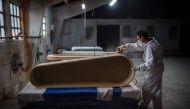 An employee makes a coffin at the Yago Gonzalez coffin-making factory in Pinor, northwestern Spain, on April 14, 2020.  AFP / MIGUEL RIOPA