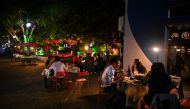 :People eat outdoor next to a restaurant in Wuhan, in China's central Hubei province on April 16, 2020. China has largely brought the coronavirus under control within its borders since the outbreak first emerged in the city of Wuhan late last year. / AFP 