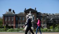 People wearing masks take a walk in Kensington Palace Park, as the spread of the coronavirus disease (COVID-19) continues, London, Britain, April 19, 2020. REUTERS/Simon Dawson