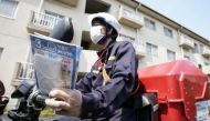 A mail carrier delivers cloth masks under a government program for the distribution of two washable masks each to all households in Japan to help contain the coronavirus disease (COVID-19) outbreak, in Tokyo, Japan April 17, 2020, in this photo taken by K