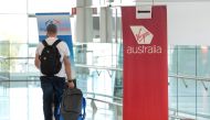 A traveller walks past a sign for Virgin Australia in the departures area at Adelaide Airport in Adelaide on April 21, 2020. AFP / Brenton Edwards 