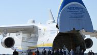 A group of officials, including President Volodymyr Zelensky, walk in front of an Antonov-225 Mriya cargo plane after its arrival with medical cargo from China, at an airfield in Gostomel outside Kiev on April 23, 2020, amid the COVID-19 coronavirus pande