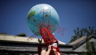 Artist Kong Ning, wearing a face mask following the coronavirus disease (COVID-19) outbreak, prepares for a portrait in a wearable art piece she made to mark Earth Day, during a Reuters interview outside her studio in Beijing, China April 22, 2020. REUTER