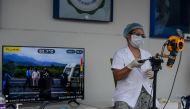 A medical staff uses a thermal scanner at an information collection and awareness desk set up by the West Bengal Health Department of Darjeeling district during a government-imposed nationwide lockdown as a preventive measure against the COVID-19 coronavi