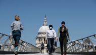 A man wearing a face mask crosses Millennium Bridge, as the spread of the coronavirus disease (COVID-19) continues, in London, Britain, April 25, 2020. REUTERS/Simon Dawson