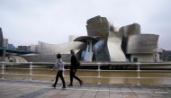 A family walks past the Guggenheim Museum, after restrictions were partially lifted for children for the first time in six weeks, during the coronavirus disease (COVID-19) outbreak in Bilbao, Spain, April 26, 2020. REUTERS/Vincent West